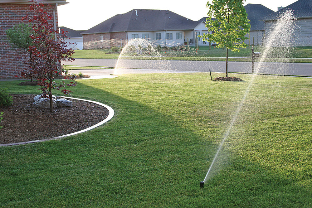 pop up Sprinkler Heads watering a lawn