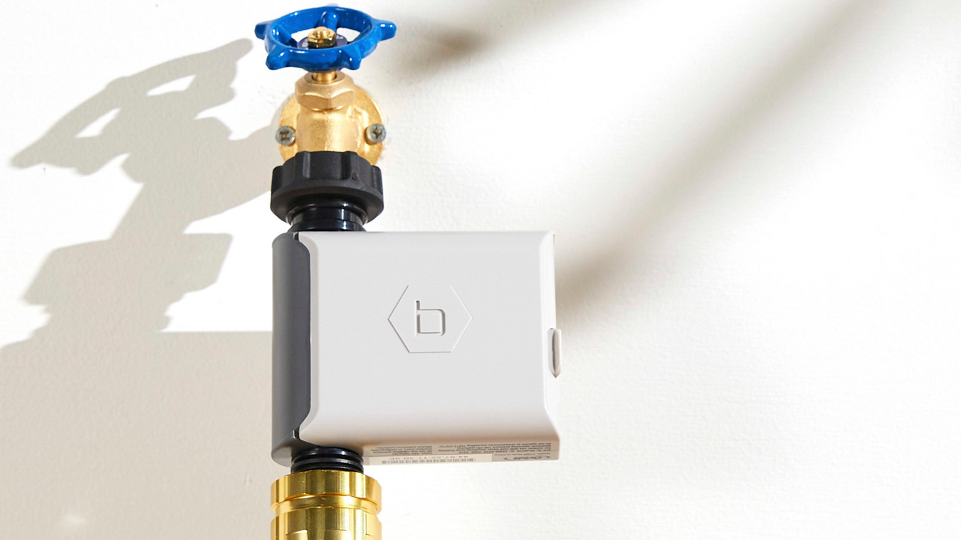 Smart valve control device attached to a brass valve on a white background