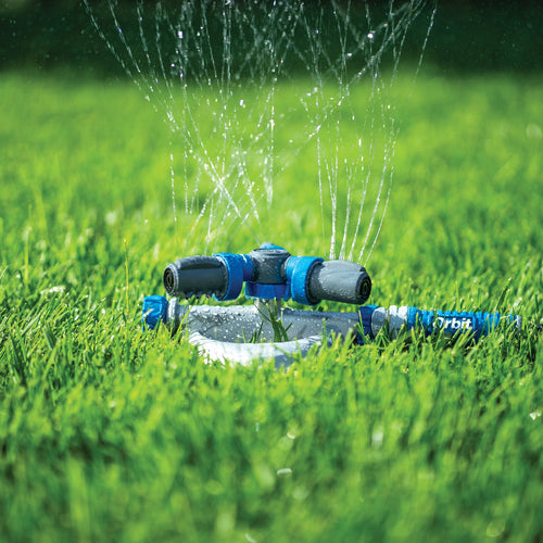 Sprinkler watering grass on a sunny day