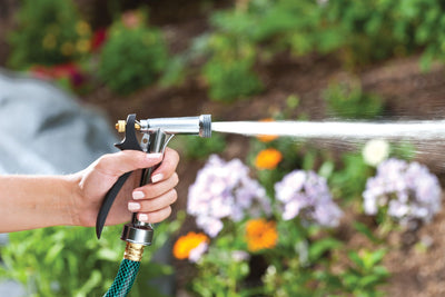 Adjustable-spray zinc rear trigger watering nozzle emitting a stream of water. 