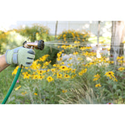 Person watering yellow flowers with a garden hose and spray nozzle.
