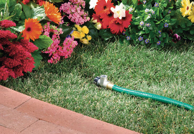 Zinc flow-through spike base for half inch male pipe thread sprinkler heads. Inserted in grass with green garden hose attached to flow-through outlet. 