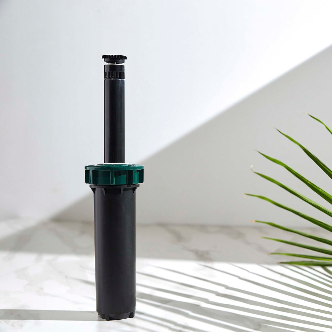 Close up of a 4-inch hard top sprinkler with 15-foot adjustable spray nozzle. Riser stem extended.