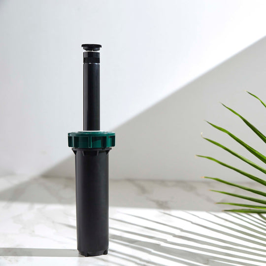Close up of a 4-inch hard top sprinkler with 15-foot adjustable spray nozzle. Riser stem extended.