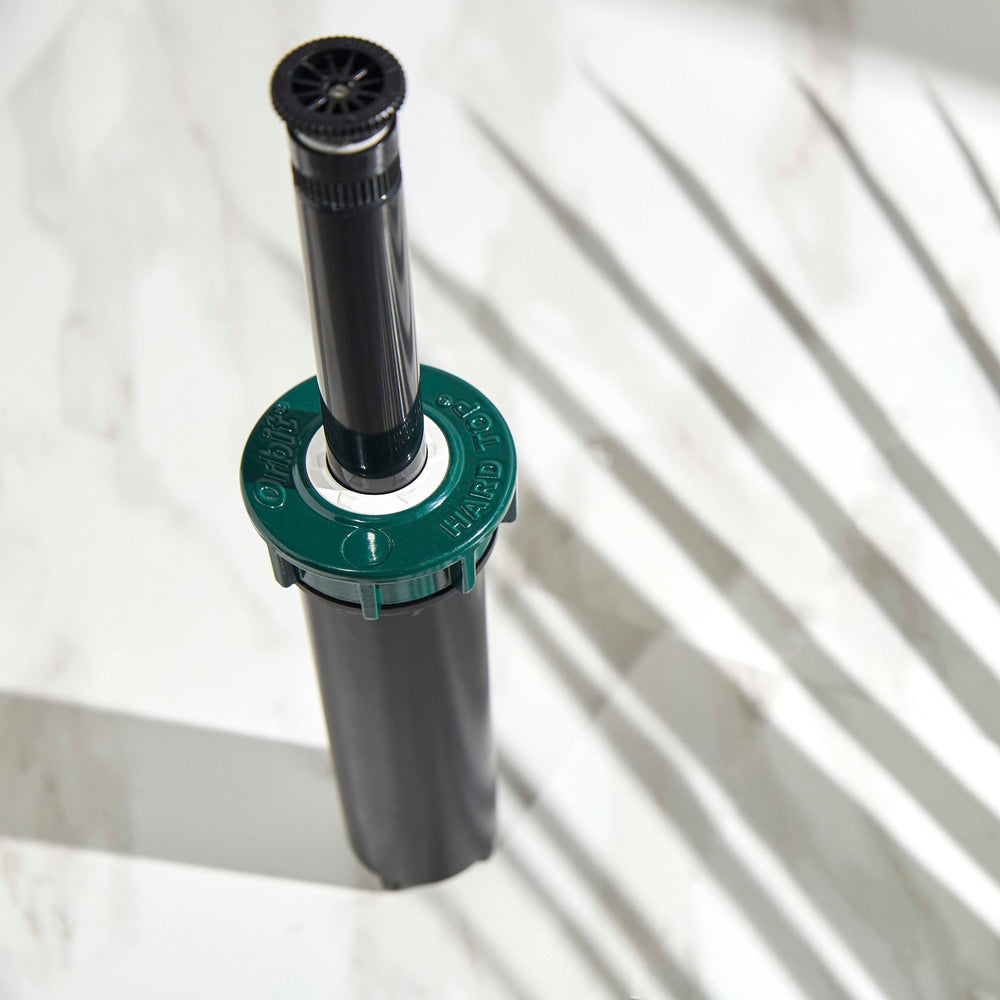Close up of extended riser stem on a 4-inch hard top sprinkler with 15-foot adjustable spray nozzle.