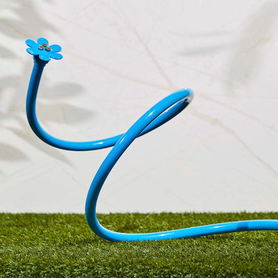 Light blue flex cobra personal mist cooling sprayer, displayed on grass. 